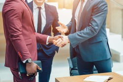 Business partnership meeting concept. Image businessmans handshake. Successful businessmen handshaking after good deal. Horizontal, blurred background