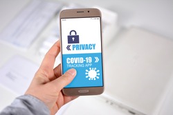 Corona Virus Tracking App privacy concerns concept with hand holding cell phone with application design showing choice between app and privacy