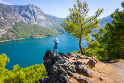 Dam lake in Green Canyon. Beatiful View to Taurus Mountains and turquoise water. Coniferous forest with green pine trees. A man stands on the edge of a cliff. Manavgat, Turkey. Turkish landscape