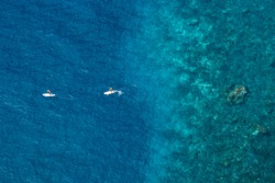 Aerial view of people doing paddle on on tropical sea.