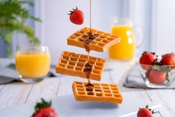 Preparation of delicious and nutritious waffles with honey, strawberries and orange juice.