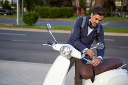 Adult male unlocking security lock on his white scooter. Anti-theft protection concept. High quality photo