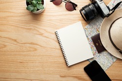 Top view of travel accessories,Traveler concept background,Blank notebook and camera on wooden table.