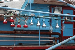 Hanging light bulb on the blue fishing boat.