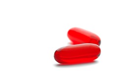 Two red capsules of medical pills isolated background