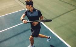 Pro tennis player practicing forehands on a club hard court. Young male tennis player playing on a club tennis court.
