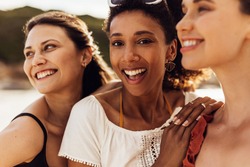 Close up of cheerful women standing outdoors. Multiethnic women friends enjoying a holiday.
