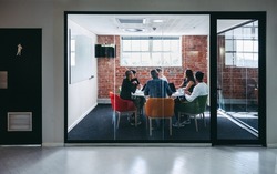 Group of businesspeople having an important meeting in a modern workplace. Creative businesspeople having a discussion while sitting together in a meeting room. Businesspeople collaborating.