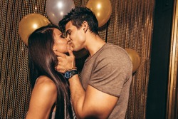 Shot of romantic young couple kissing in the night club. Man and woman in the pub.