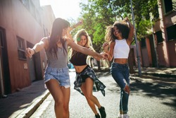 Outdoor shot of young women having fun on city street. Female friends enjoying a day around the city.