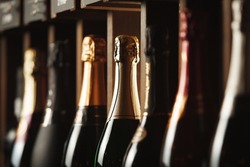 Bottles of champagne on the shelf, close-up image of alcoholic beverages in the wine cellar. Close-up image.