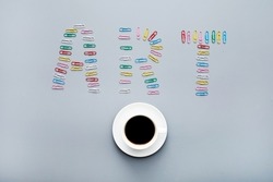 Modern art concept: directly above view of colorful paper clips laid out in shape of art inscription and coffee cup
