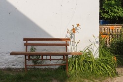 Old bench near the white shed wall. Rural yard