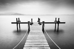 Wooden pier on the lake. Fog. Long exposure. Black and White.