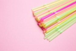 Colored cocktail straws close-up on a pink isolated background