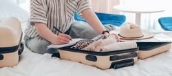 Travel. Online travel plans with Covid passport and Covid test. Traveling after quarantine, lockdown,Staycation.local travel new normal.Girl packs baggage in suitcase and travel documents