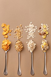 Spoons of various cereals view from above. Corn flakes, oat flakes, muesli, granola assortment. Top view