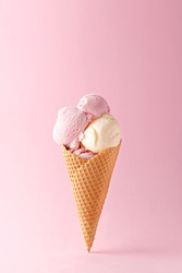 Ice cream cone vanilla and strawberry flavors on a pink background. Copy space