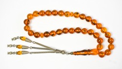 Yellow amber prayer beads (rosary) on white background