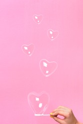 Heart shaped soap bubbles on pink background for St Valentine's Day