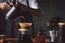 Coffee shop concept : Professional barista preparing coffee using chemex pour over coffee maker and drip kettle. Alternative ways of brewing coffee.