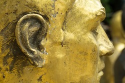 Closeup of unfinished bronze head. Focus on cheek and ear.