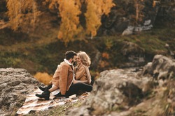 Happy in love romantic young cheerful couple man and woman married travel hiking walk together among the autumn forest and mountains looking for adventure enjoy the local nature, selective focus