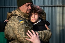 Teen son says goodbye to her military father. Son hugs a dad Ukrainian soldier. Ukrainian defender says goodbye to his family. Mobilization of Ukrainian men. War in Ukraine. Defenders of Ukraine