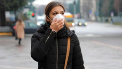 COVID-19 Pandemic Coronavirus Woman in city street wearing protective face mask for spreading of disease virus SARS-CoV-2. Girl with protective mask on face against Coronavirus Disease 2019.