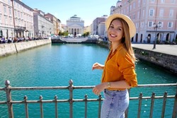 Traveler girl standing on the bridge with beautiful view of Trieste city, Italy