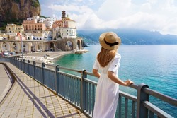 Holidays on Amalfi Coast. Back view of beautiful fashion girl enjoying view of Atrani village on Amalfi Coast. Summer vacation in Italy.