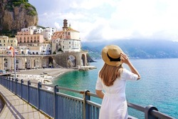 Tourism on Amalfi Coast. Back view of beautiful fashion girl enjoying view of Atrani village on Amalfi Coast, Italy. Summer vacation in Europe.