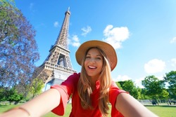 Selfie girl in Paris, France. Young tourist woman taking self portrait with Eiffel Tower in Paris.