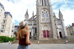 Tourism in France. Back view of beautiful tourist girl visiting the city of Nantes, France.