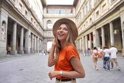 Portrait of young woman walking in courtyard of historic Uffizi Gallery art museum in Florence, Tuscany, Italy