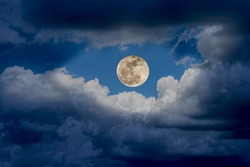 The big super moon shines wonderfully with the white clouds in the sky at night, nature background.
