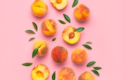 Summer fruit background. Flat lay composition with peaches. Ripe juicy peaches with green leaves on pink background. Flat lay top view copy space. Fresh organic fruit vegan food. Harvest concept