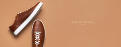 Leather brown men's sneakers with white laces and rubber soles on beige background. Flat lay top view. Men's sports casual shoes. Fashionable sneakers. Male fashion hipster footwear Minimal background