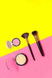 Cosmetic makeup Set. Professional makeup brushes, powder, eyeshadow, blush, lipstick on yellow pink background flat lay top view copy space. Beauty product women's accessory fashion. Different brushes