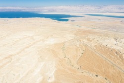 Aerial panoramic view of the Dead Sea and the ancient fortification Masada in the Southern District of Israel situated on top of an isolated rock plateau, eastern edge of the Judaean Desert, Israel