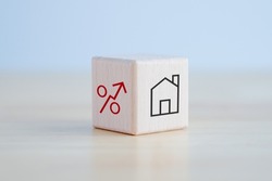 House and property investment and asset management concept. Loan, Mortgage, Inflation, Sale and tax rise. House icon and percentage sign on wooden block. Home price or increase of interest rate.