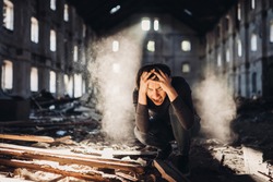Sad depressed person in abandoned destroyed building crying.Emotional portrait.Screaming woman in excruciating pain.Problem,stress and disappointment.Disaster in life,lost and grief.Madness and trauma