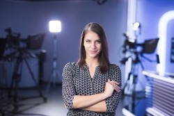 Young beautiful brunette television announcer at studio standing next to the camera.TV director at editor in studio.Recording at TV studio with television anchorwoman. TV NEWS studio behind the scenes