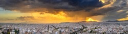 Panorama of the Greek capital Athens at sunset with a sky overcast with thunderclouds, Greece, Europe. View of the city from above