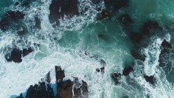 Aerial view of crashing waves on rocks. Aerial view of sea waves and fantastic Rocky coast,Background texture of a rocky shore and blue and turquoise water and waves of the Atlantic Ocean New Zealand.