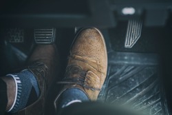 Man foot press the break  pedal of a car.