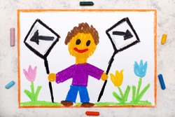 Photo of colorful drawing: Left and right arrow signs. Future and past concept. Smiling boy holding two signs.