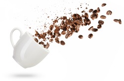 coffee beans spilled out of a cup isolated on white background