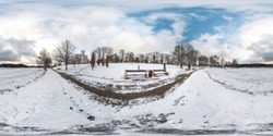 Winter full spherical seamless panorama 360 degrees angle view on road in a snowy park with blue sky near frozen city lake in equirectangular projection. VR AR content