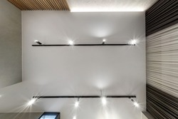 suspended or stretch ceiling with halogen spots lamps and drywall construction in empty room in apartment or house